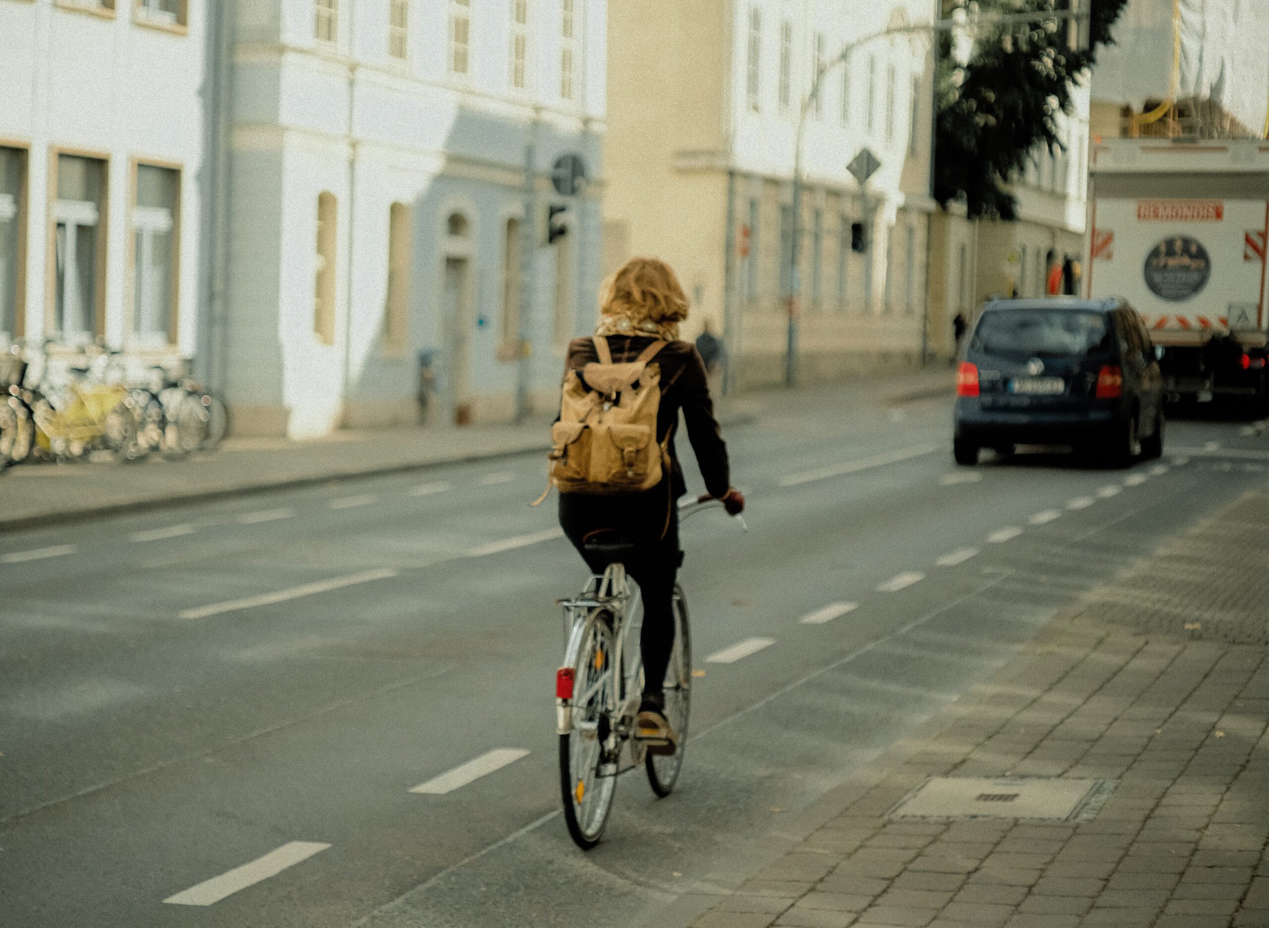 Bilden visar en person som cyklar. Cykelparkering med låsbara cykelställ förenklar vardagsanvändandet av cykeln.